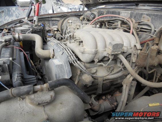 engine bay with jumper cables attached to battery, 2400 fourcam engine visible