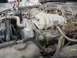 1986 Ford Bronco - Jumper cables are connected to the battery in this dusty engine bay, showing a 2400 FourCam engine.