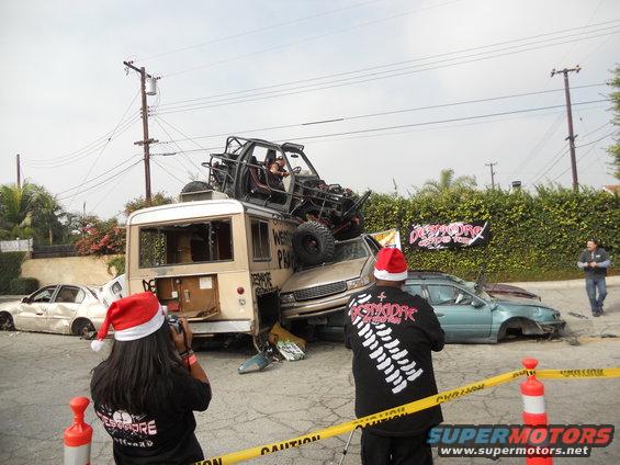 Chaotic scene of wrecked vehicles with people in Santa hats