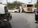 1986 Ford Bronco - Multiple wrecked vehicles and a bus are visible in a yard, with a large off-road vehicle in the foreground.