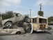 1986 Ford Bronco - A chaotic scene with a truck precariously balanced atop other wrecked vehicles.