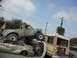 1986 Ford Bronco - A chaotic scene of multiple damaged vehicles piled up, with a pickup truck precariously balanced.