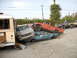 1986 Ford Bronco - A chaotic scene of damaged vehicles piled atop one another in an outdoor lot.
