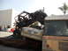 1986 Ford Bronco - A heavily modified off-road vehicle is piled on top of other cars in a junkyard scene.