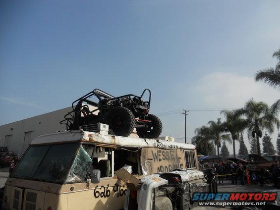 Buggy on van roof, van has '626 966' on side and 'WESSEX OFFROAD' on top. Other vehicles and people in background