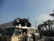 1986 Ford Bronco - A custom buggy is loaded onto the roof of a modified van, with a crowd gathered in the background.