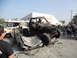 1986 Ford Bronco - A heavily modified off-road buggy is perched atop a severely damaged car, with a wrecked van nearby.