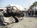 1986 Ford Bronco - A heavily modified off-road buggy is shown perched atop a severely damaged car, with spectators in the background.