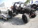 1986 Ford Bronco - Custom off-road buggy with roll cage and large tires sits beside wrecked vehicles.