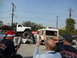1986 Ford Bronco - A lifted pickup truck is parked on top of several wrecked cars, with a van in the background.