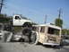1986 Ford Bronco - Modified pickup truck rests precariously atop a wrecked bus and car, with 'DESMADRE OFF ROAD TEAM' spray-painted on the bus.