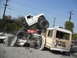 1986 Ford Bronco - A monster truck has crushed several vehicles, including a bus, in a chaotic scene.