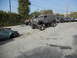 1986 Ford Bronco - A heavily modified panel van with off-road tires is parked on a street, with other vehicles in the background.