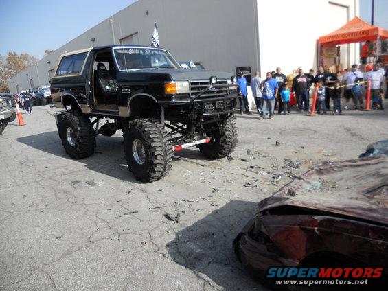 lifted black Bronco with tan top, front end damaged car in foreground