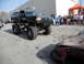 1986 Ford Bronco - A heavily modified Bronco is parked next to a wrecked car, with onlookers in the background.