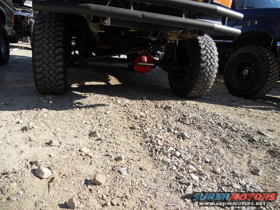 Rear underside of a lifted 1987 Ford Bronco with large tires and a red differential