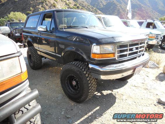 Dark blue 1992 Ford Bronco with lifted suspension and off-road tires parked outdoors