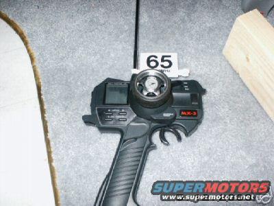 RC remote control with 'MX-3' and '65 MHz' labels, on a carpeted surface