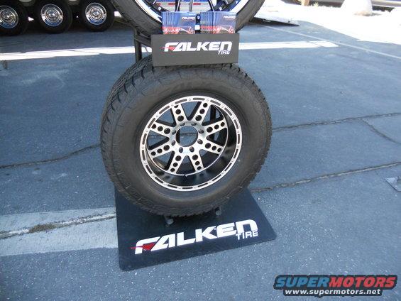 Falken tire on a display stand with brochures, part of a larger tire display in background