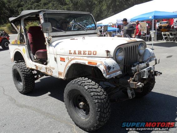 White Jeep CJ-7 Laredo with red interior, lifted suspension, and off-road tires