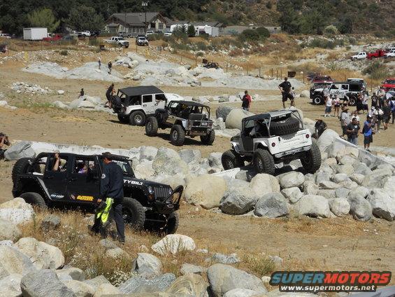 Black and white Jeep Wranglers navigating a rocky obstacle course