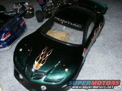 green remote control car body with flames on hood, Pontiac logo on windshield, next to blue car body