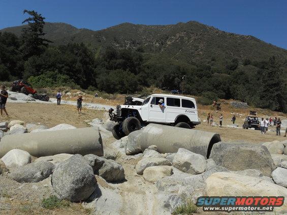 White off-road wagon navigating rocky terrain