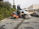 1986 Ford Bronco - A forklift is used to stack a white car on top of a tan car, with a propane truck in the background.