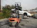 1986 Ford Bronco - A forklift lifts a white car, which is precariously balanced on top of another vehicle, in front of a Wessel Propane truck.