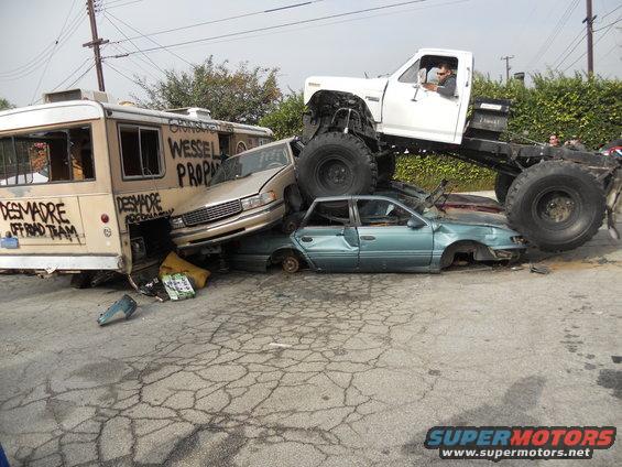 Monster truck crushing multiple cars, including a bus