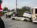 1986 Ford Bronco - A lifted truck has crushed several cars, creating a chaotic scene with a bus nearby.