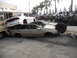1986 Ford Bronco - A chaotic scene of crushed vehicles, with a white sedan precariously balanced atop a tan sedan.