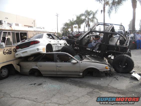 Modified off-road vehicle atop wrecked cars