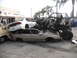 1986 Ford Bronco - A custom-built off-road vehicle is piled on top of several other damaged cars in a junkyard scene.