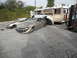 1986 Ford Bronco - Multiple wrecked vehicles are visible, including sedans and a propane truck, with a forklift nearby.