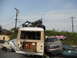 1986 Ford Bronco - A chaotic scene of crushed and piled vehicles, including a bus with graffiti, a sedan, and a buggy perched precariously on top.