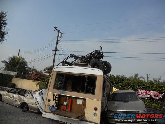 Off-road buggy loaded onto a van, with a sedan and minivan also visible