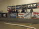 1986 Ford Bronco - Spectators watch a remote control car race on an indoor track, with various racing brand banners displayed above.