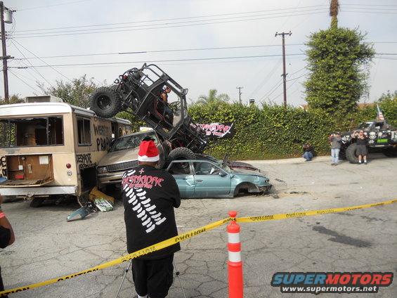 Wrecked vehicles including a bus, a sedan, and a roll cage buggy piled up