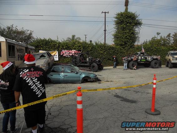 wrecked cars and trucks with people in santa hats, caution tape up