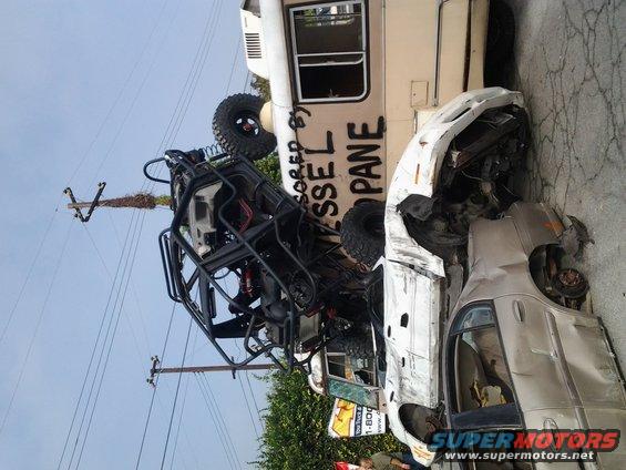 Wrecked cars and a utility vehicle piled up, with text on a van reading 'DIESEL PROPANE'