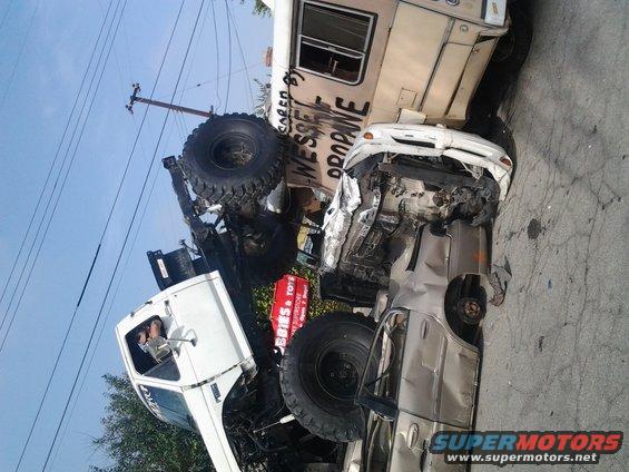 Wrecked pickup truck crushed by RV, text on RV reads 'WESSEX PROPANE'