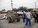 1986 Ford Bronco - A group of people gather around modified trucks, one with an American flag, on an overcast day.