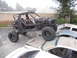 1986 Ford Bronco - A heavily modified buggy is parked on top of several other vehicles in a junkyard.