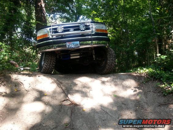 1995 Ford Bronco front view on dirt trail with trees in background. License plate BY3-5006