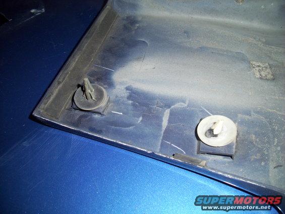 Close-up of a blue plastic trim piece with two mounting clips attached