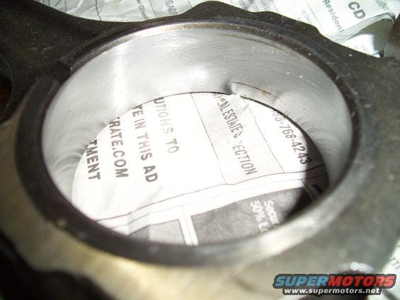 Engine connecting rod bearing with newspaper showing real estate section