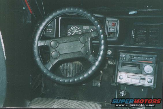 Black interior of a 1985 Volkswagen Scirocco, showing the dashboard, steering wheel, and center console