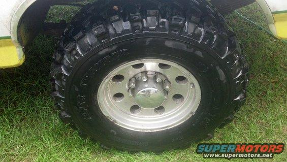 Close-up of a large off-road tire and silver wheel on a vehicle