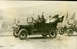 1909 Ford Model T - Passengers ride in a touring car, with another vehicle visible behind it, during what appears to be a parade or celebration.